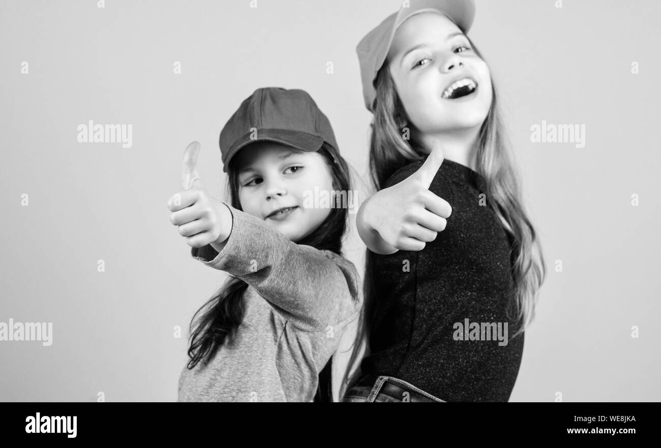 Cool girls. Little cute girls wearing bright baseball caps. Modern