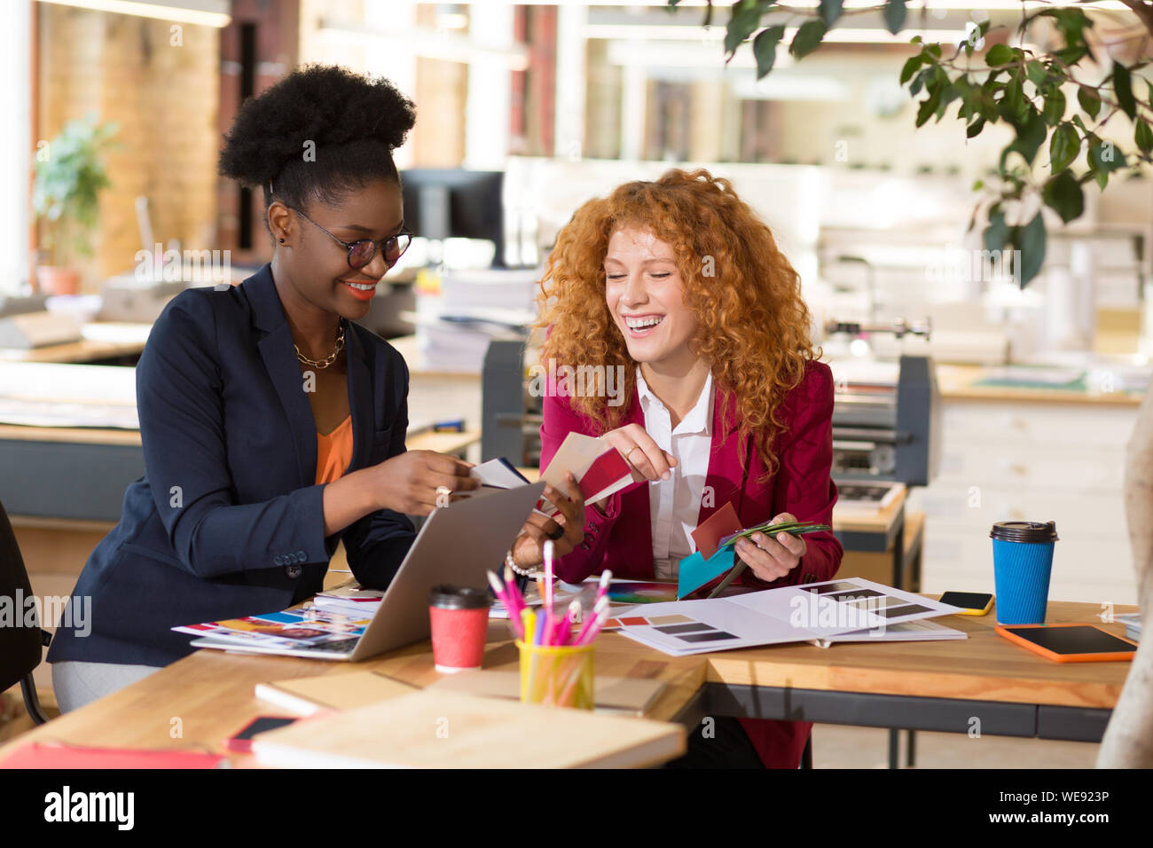 Interior designers laughing while working together in the office Stock Photo