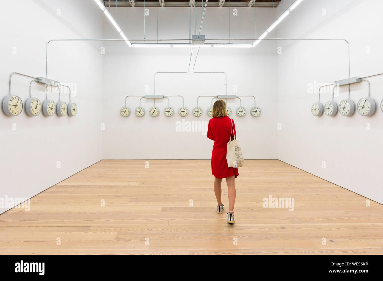 Art gallery woman, view of a woman in a red dress looking at artwork by Agustina Woodgate (National Times), Whitney Museum Of American Art, NYC, USA Stock Photo