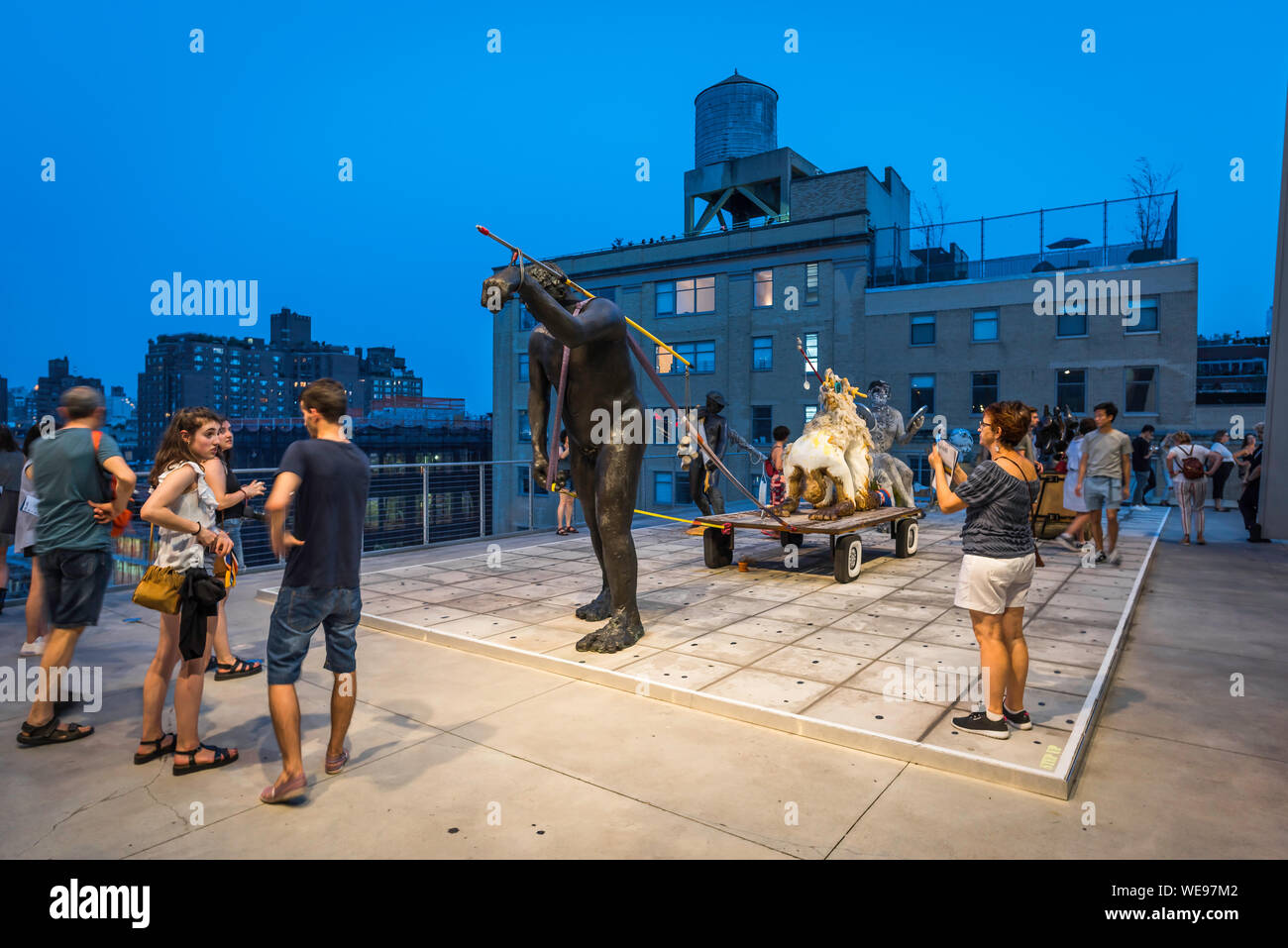 New York art scene, view at night of people looking at artwork by