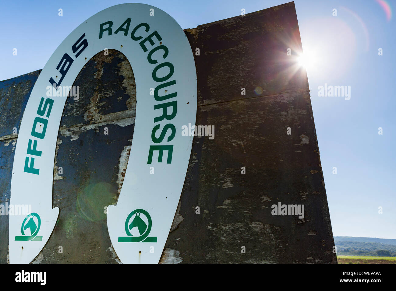 The winnining post at Ffos Las racecourse, shot into sun with flare Stock Photo