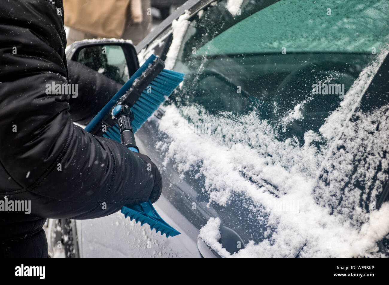 Person Removing Snow On Car Stock Photo