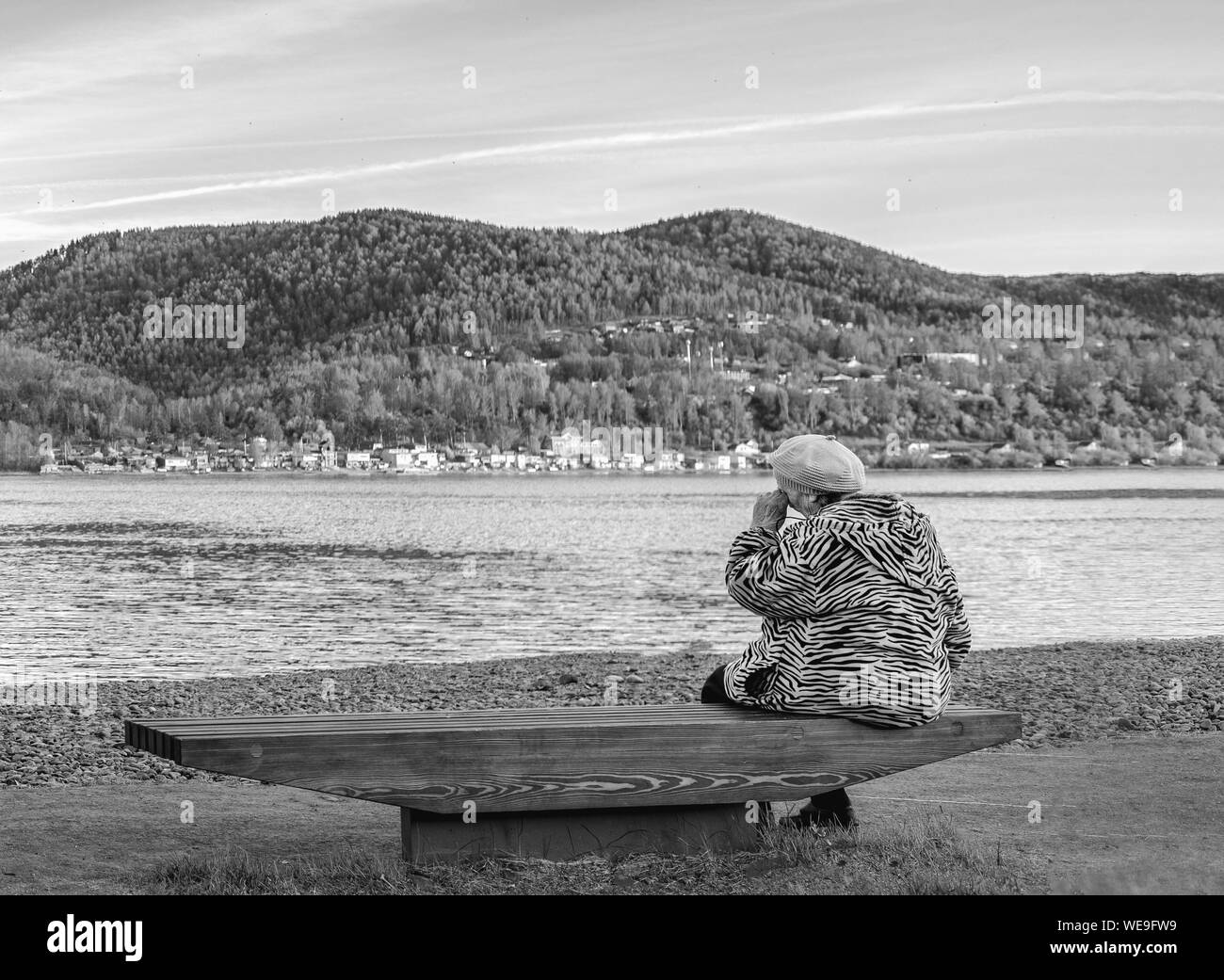 Krasnoyarsk, Russia, July 29, 2019: the old grandmother is sad and crying on the Bank of a beautiful river. black and white dramatic photo. Stock Photo
