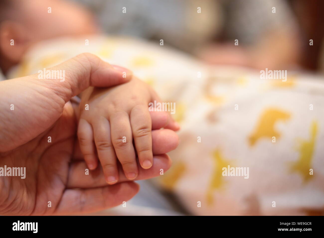 Parent Holding A Baby Hand Baby Sleeping While Holding Hand For