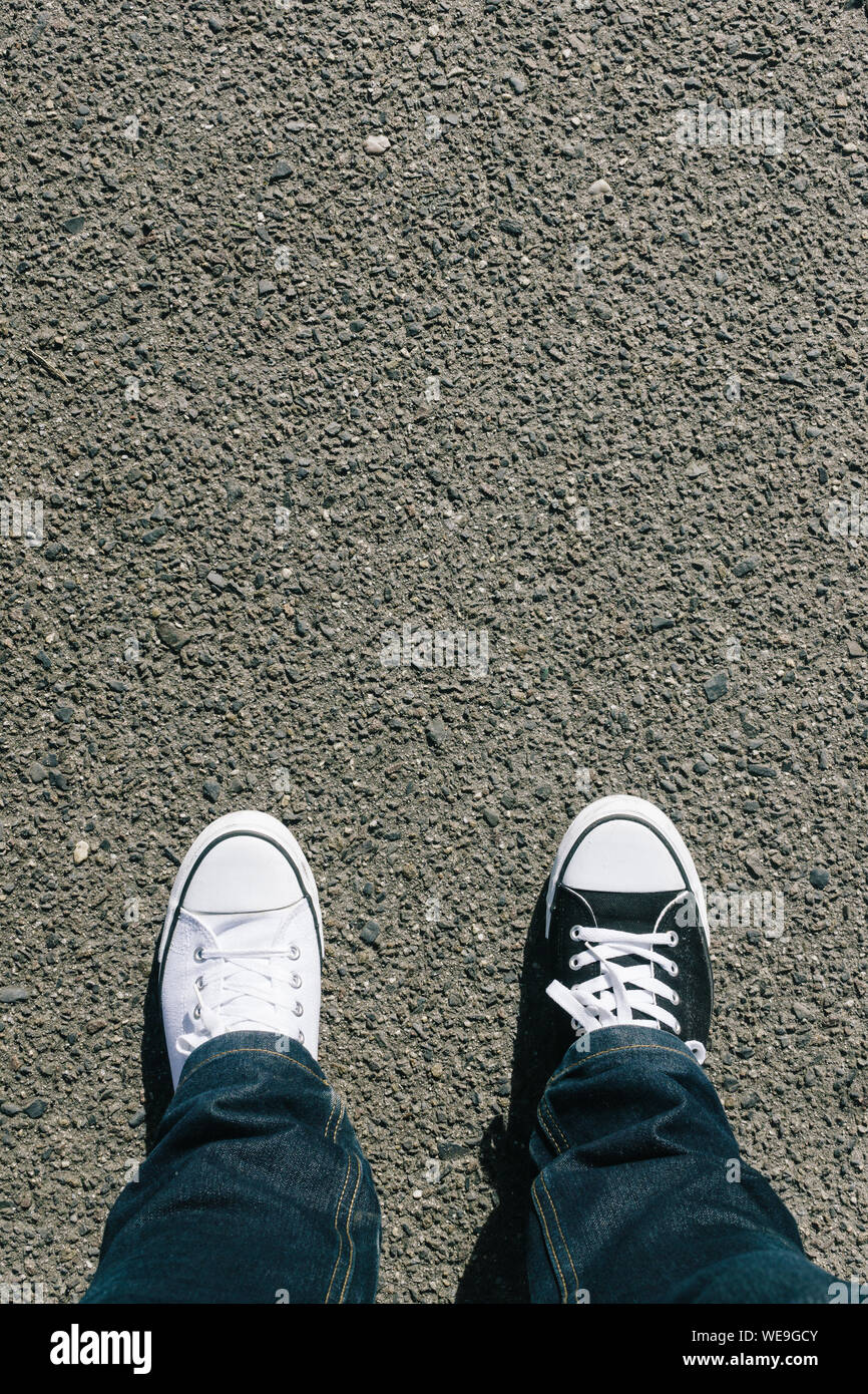 Low Section Of Man Wearing Different Shoes On Street Stock Photo - Alamy