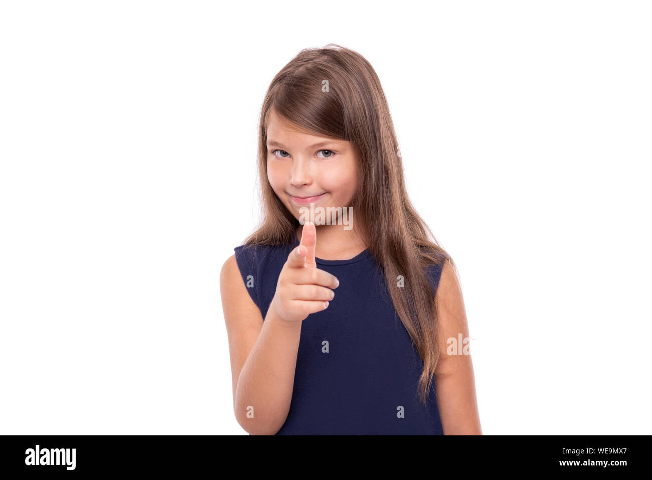 Little girl points her finger at you isolated on white. Stock Photo