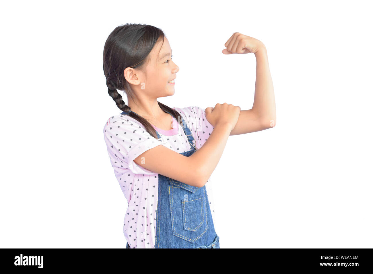 Girl Flexing Muscles While Standing Against White Background Stock Photo