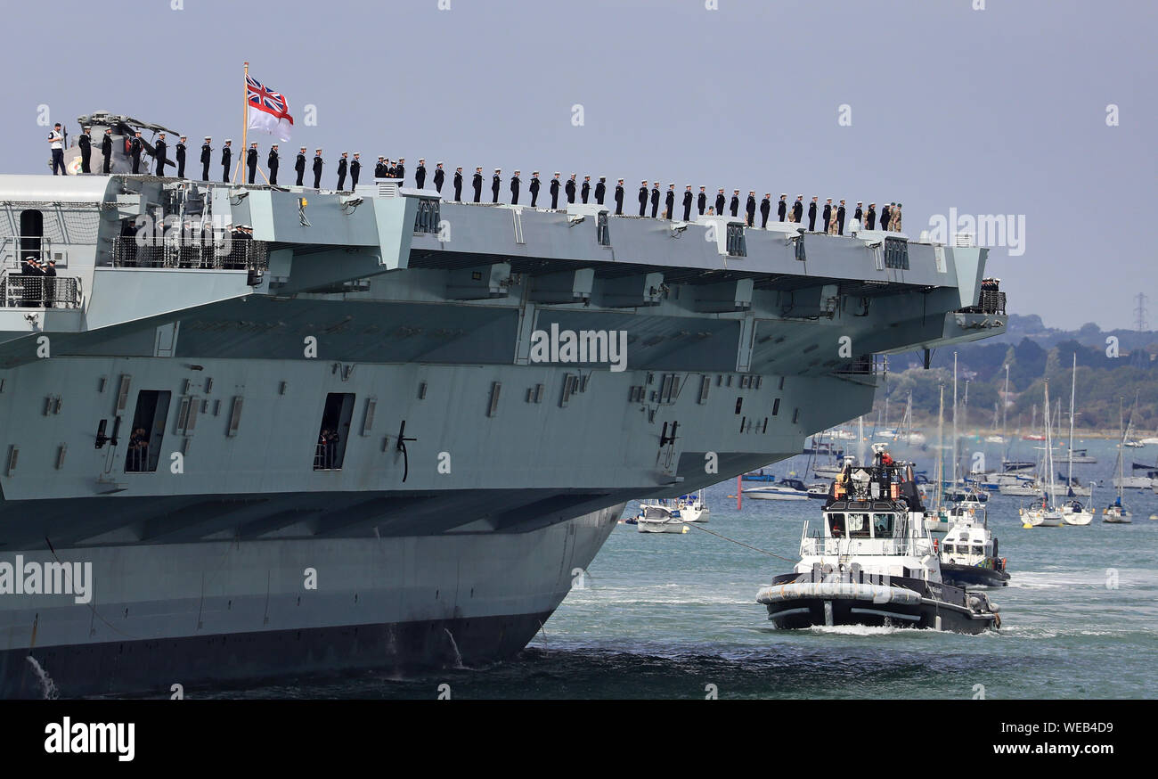 Members of the ship's company stand on deck as HMS Queen Elizabeth sets sail from Portsmouth Naval Base, for deployment to the United States. Stock Photo