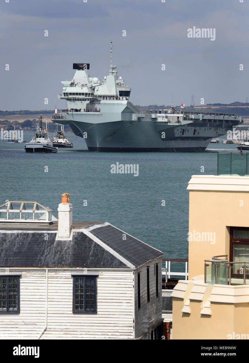 Members of the ship's company stand on deck as HMS Queen Elizabeth sets sail from Portsmouth Naval Base, for deployment to the United States. Stock Photo