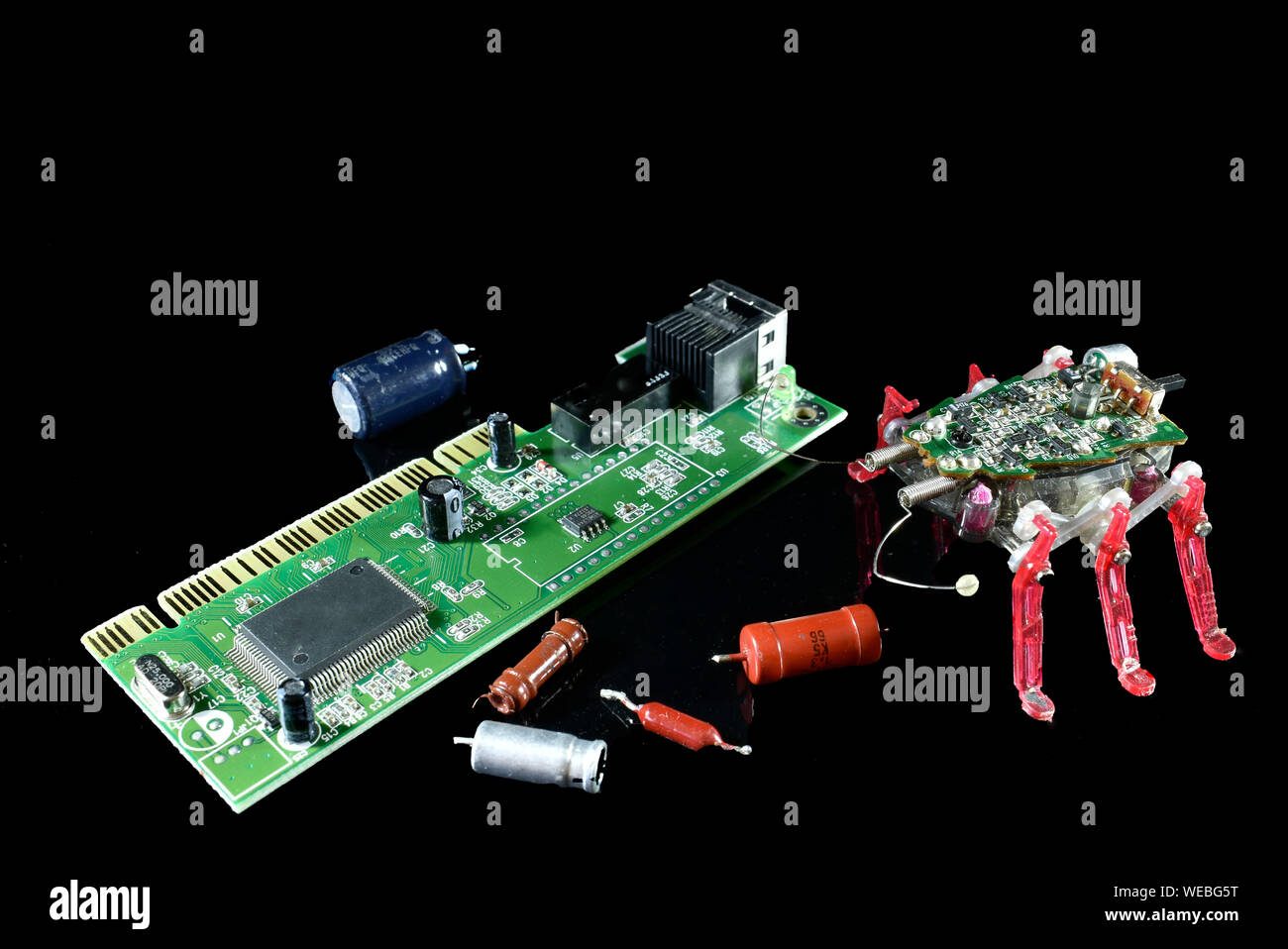 Electronic insect , computer bug , sitting near a circuit board with electronic components aside , conceptual image about internet security Stock Photo