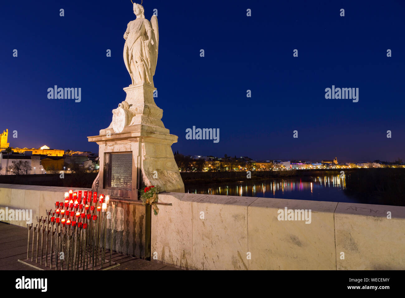 Cordoba,Spain,2,2014;Candles and statue of the Archangel of St. Gabriel on the Roman bridge. Stock Photo
