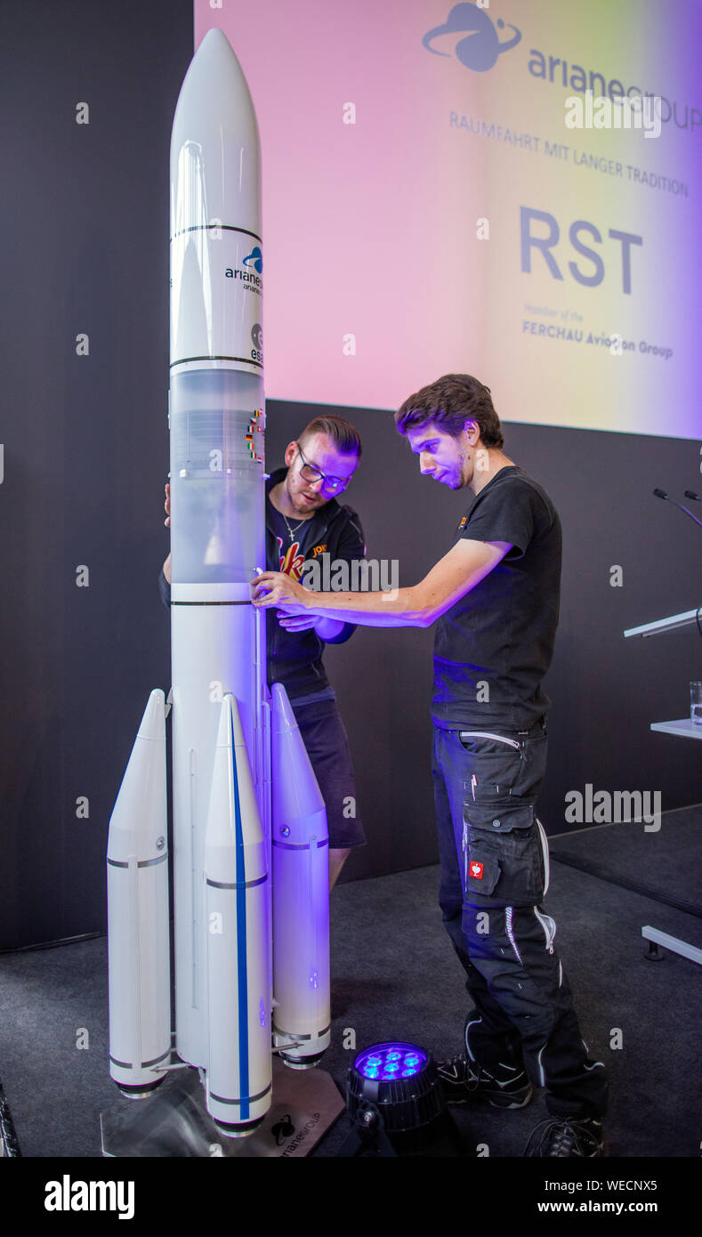 Rostock, Germany. 30th Aug, 2019. Before the event begins, technicians set up the model of an Ariane 6 launch vehicle on stage. With the symbolic first steel cut, the company Rostock System-Technik GmbH (RST) started the construction of large jigs for the construction of the European launcher without press support. RST stated that these were lifting devices, work platforms or transport carriages, not rocket parts. Without these assembly devices and special tools from Rostock, the upper stage of the Ariane 6 in Bremen could not be built. Credit: Jens Büttner/dpa-Zentralbild/dpa/Alamy Live News Stock Photo