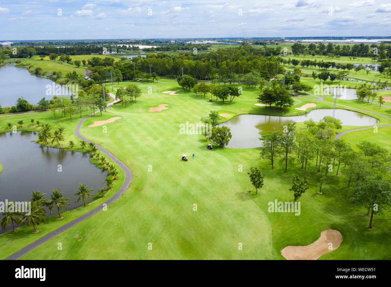 Aerial view of pound on golf course with player, footpath on golf course, playr enjoying the game under sun, golf field. Stock Photo