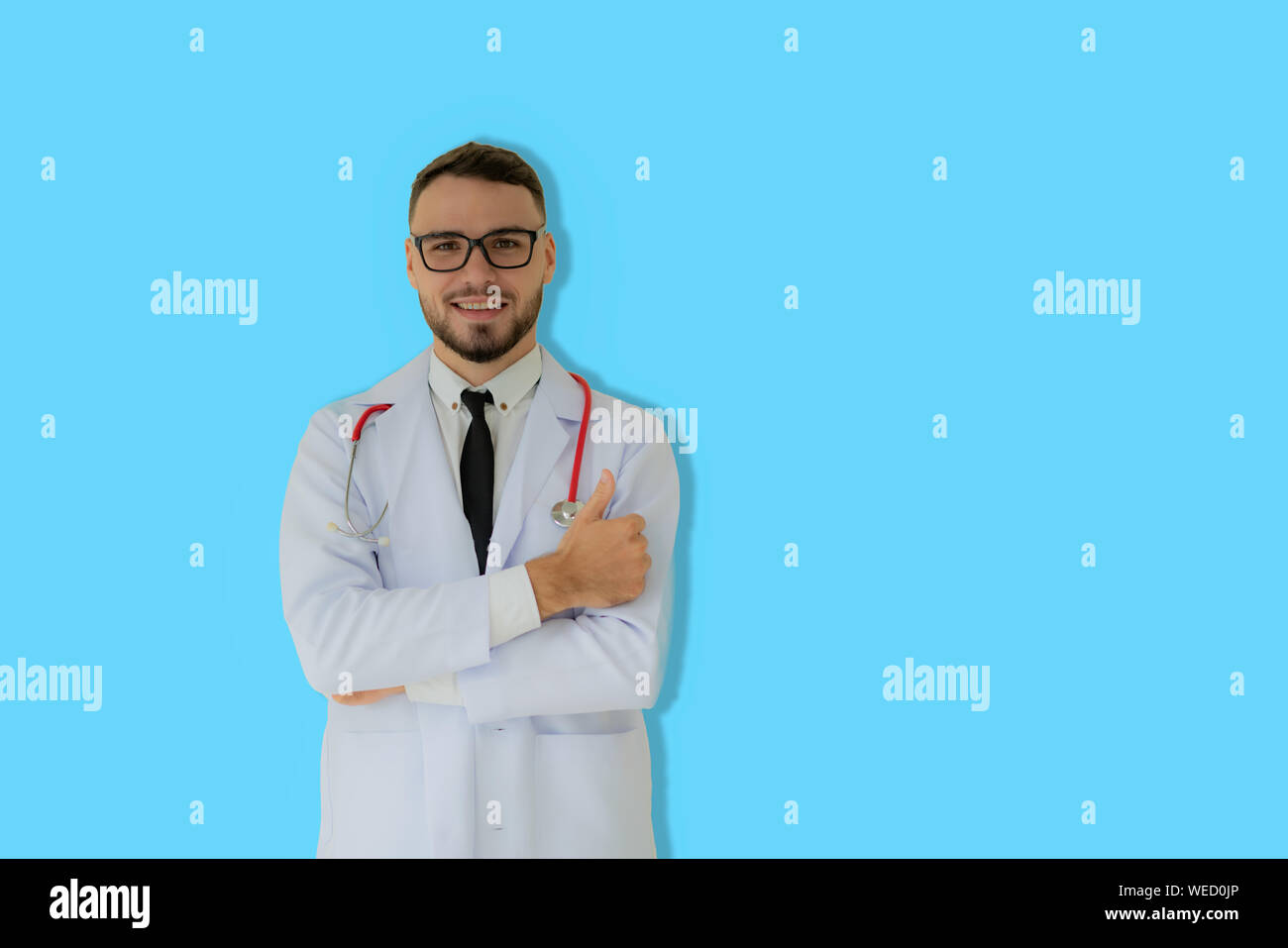 Positive minded practitioner posing with thumbs up with blue background. Stock Photo