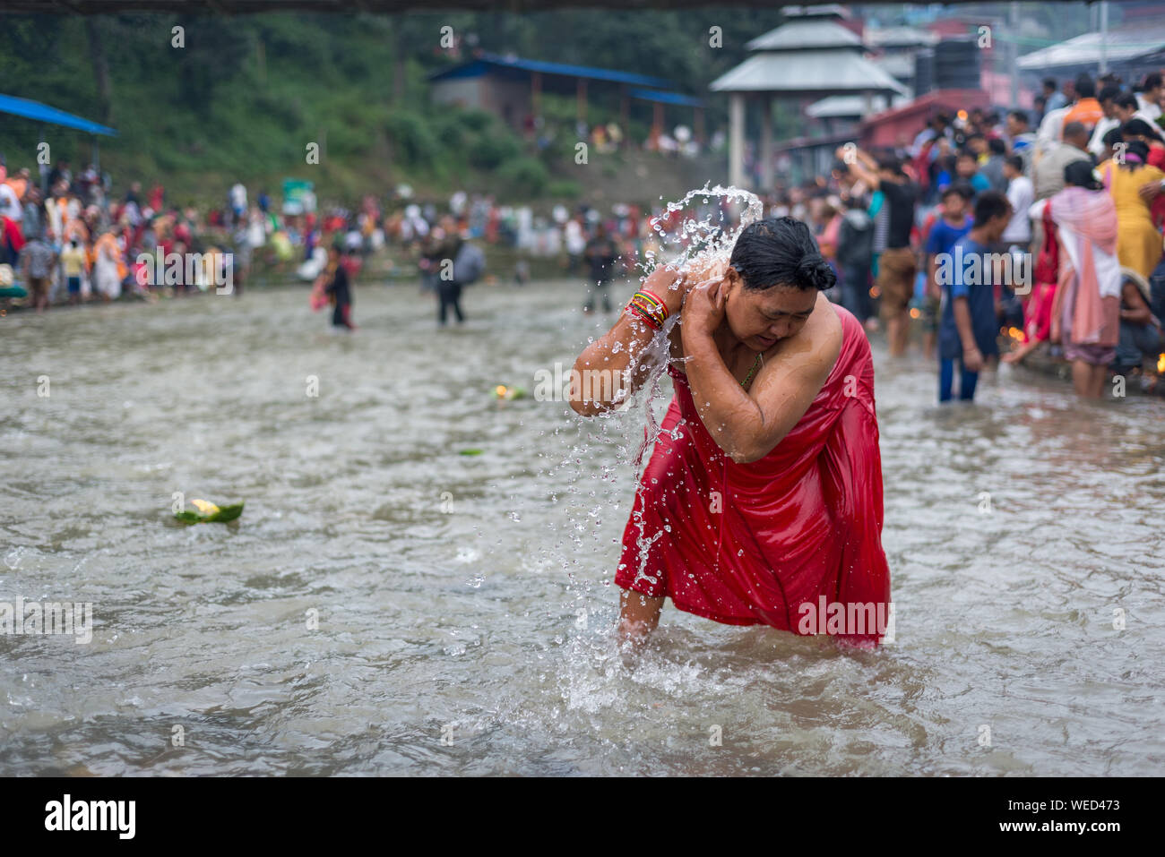 A women takes a holy bath during the rituals.Nepalese perform rituals