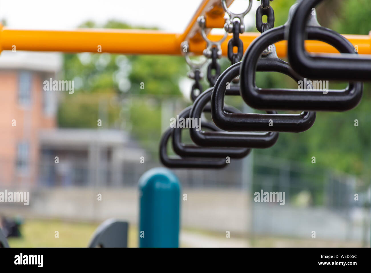 Empty monkey bars at a playground concept looking through at goals and holding on strong preventing falling and maintaining balance. Stock Photo