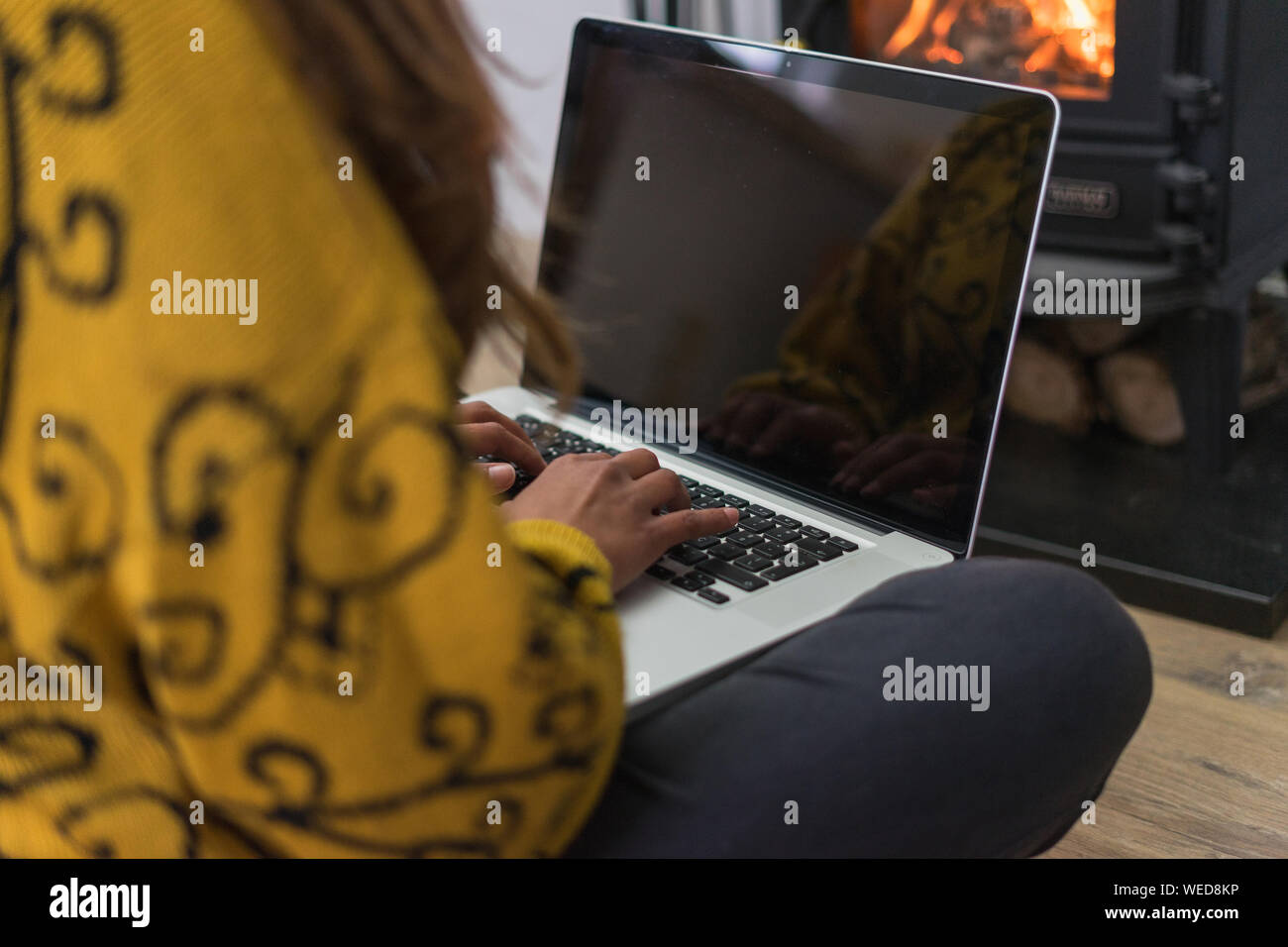 Woman Seated On The Floor Working On Her Laptop Computer In Front