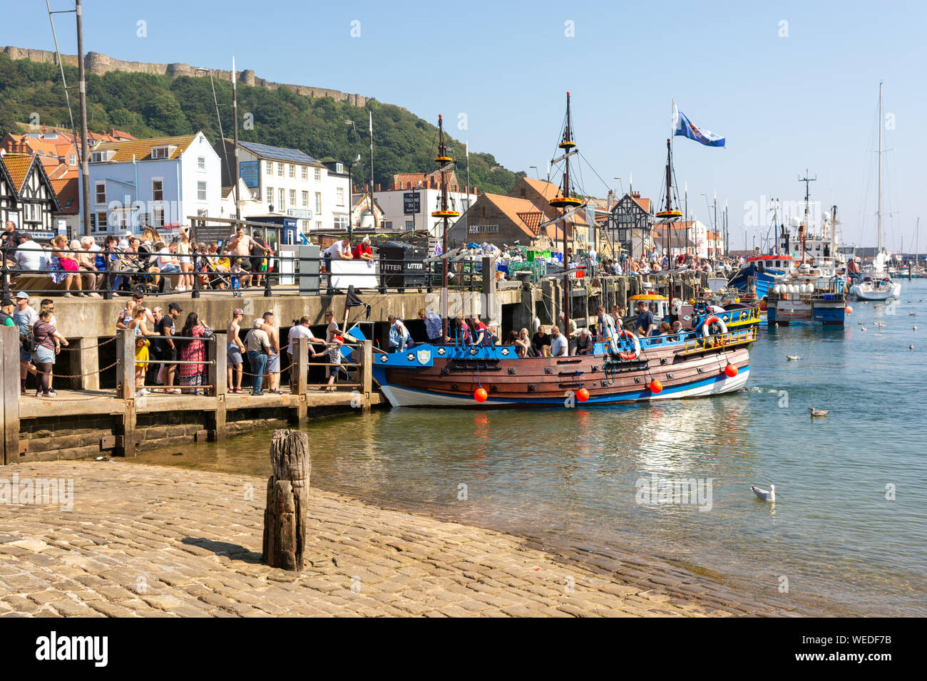 Pleasure boats and crowds of people on the quay and quayside at Scarborough, North Yorkshire, UK, during August bank holiday heatwave, 2019 Stock Photo