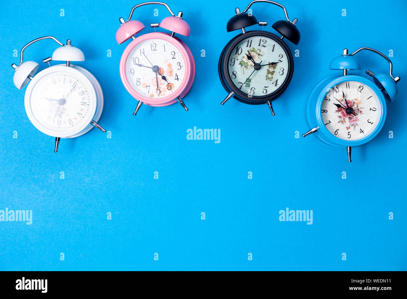 Flat lay of beautiful new alarm clock on blue paper background Stock ...