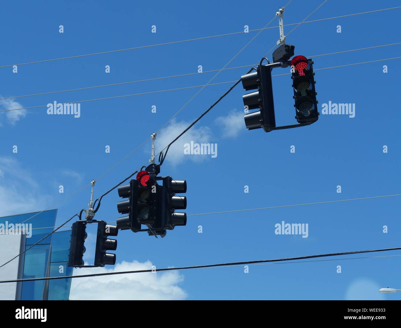Upward shot of traffic lights hanging from wires Stock Photo
