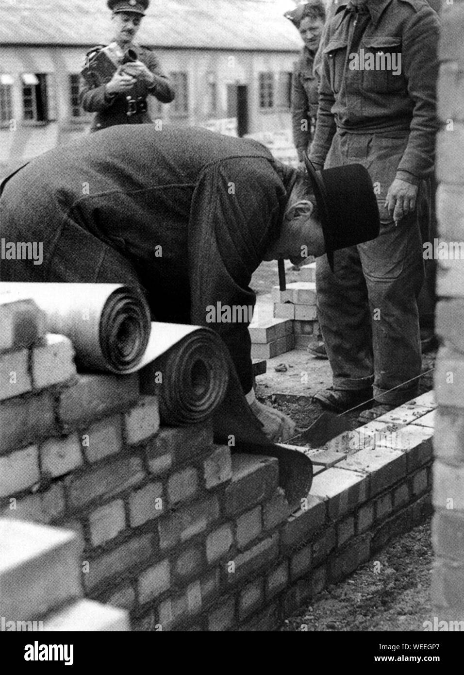 Winston Churchill bricklaying at an anti-aircraft battery. April 1942 Stock Photo