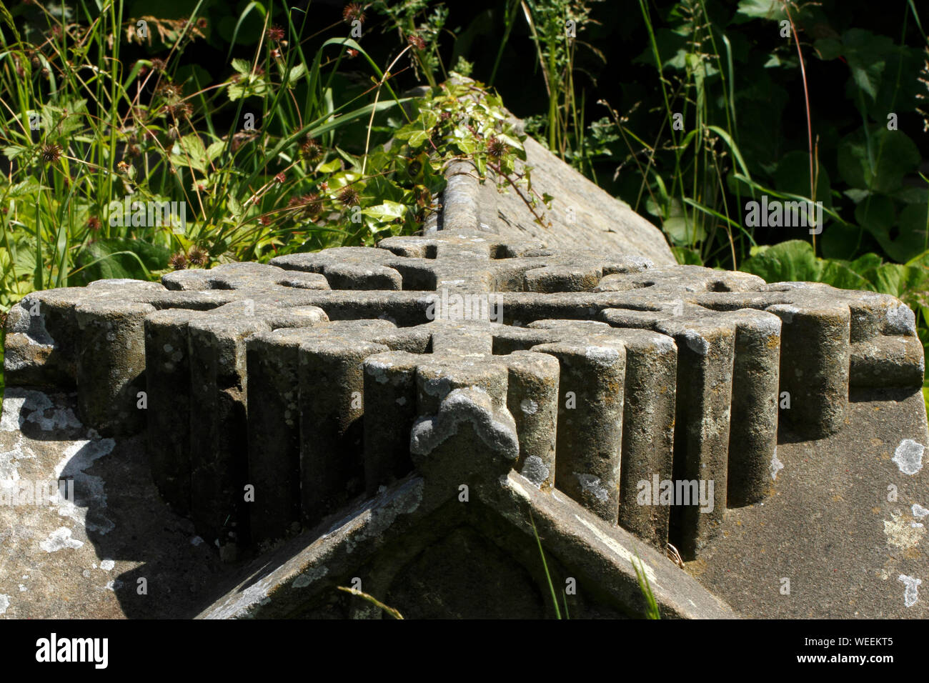 decorative cross on top of a tomb, in a Welsh Graveyard. Stock Photo