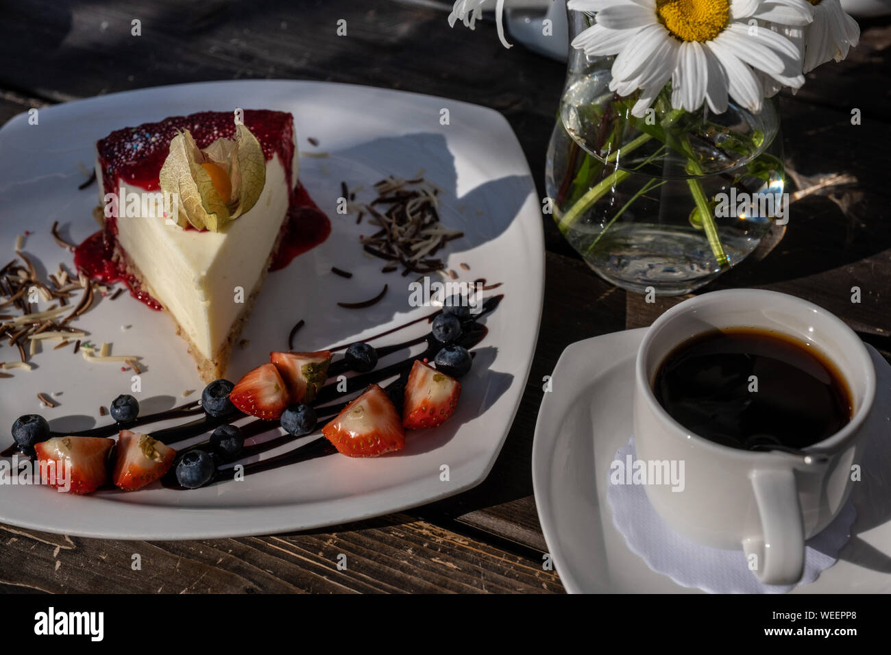classic cheesecake with raspberry jam on a plate decorated with fresh