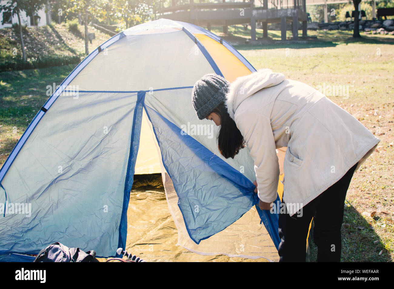 Woman Adjusting Tent On Field Stock Photo