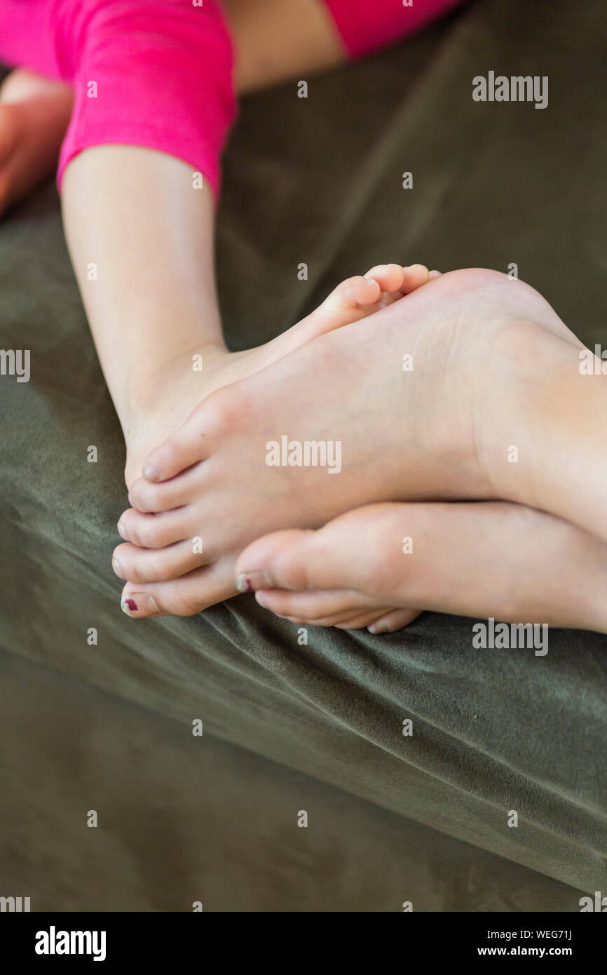 Large and small girls' feet touching Stock Photo