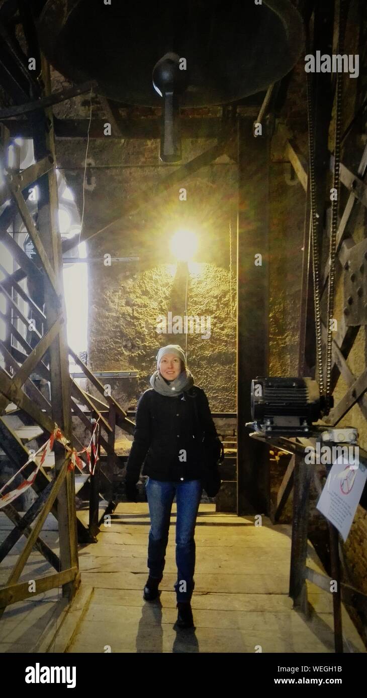Woman Looking At Bell While Standing In Tower Stock Photo