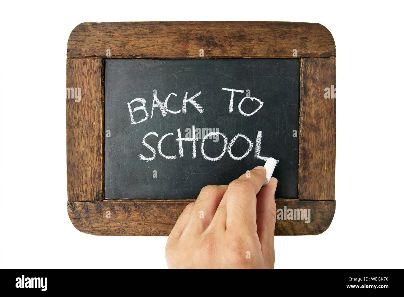 Cropped Hand Writing Back To School On Blackboard Over White Background Stock Photo