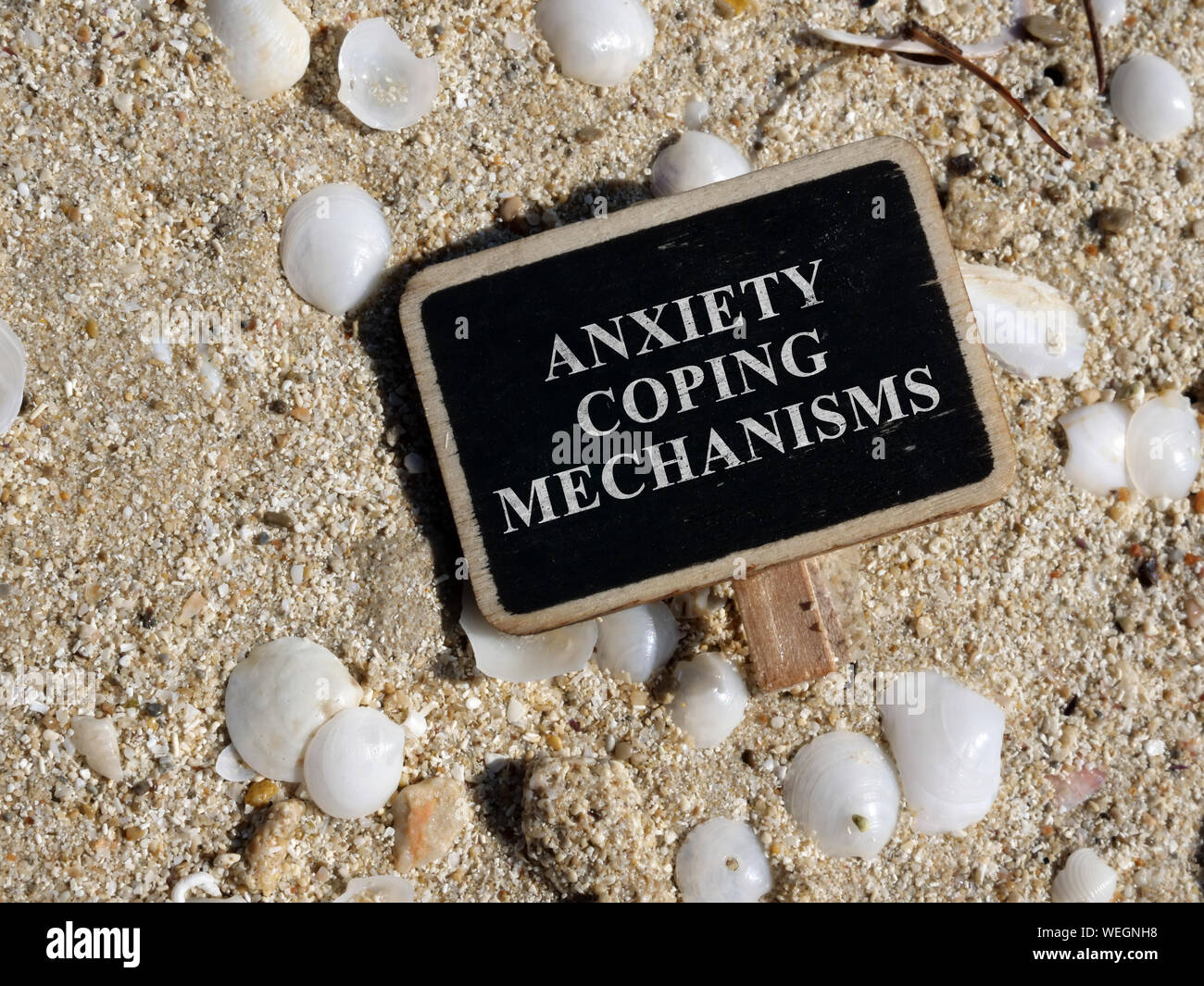 Plate with the inscription Anxiety coping mechanisms lies on the beach. Stock Photo