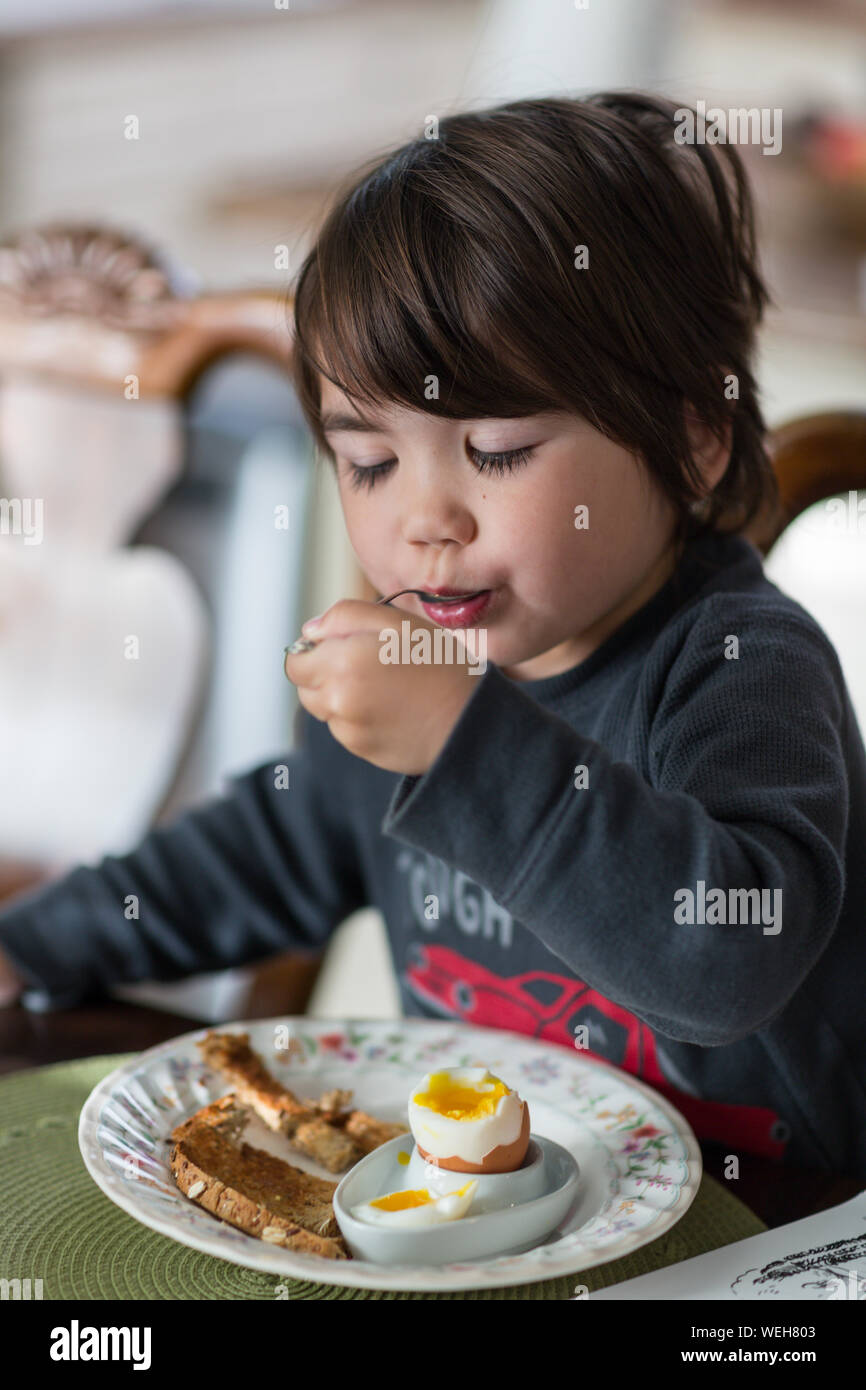 6 year old boy of Asian mixed ethnicity eating breakfast, San Jose, California Stock Photo