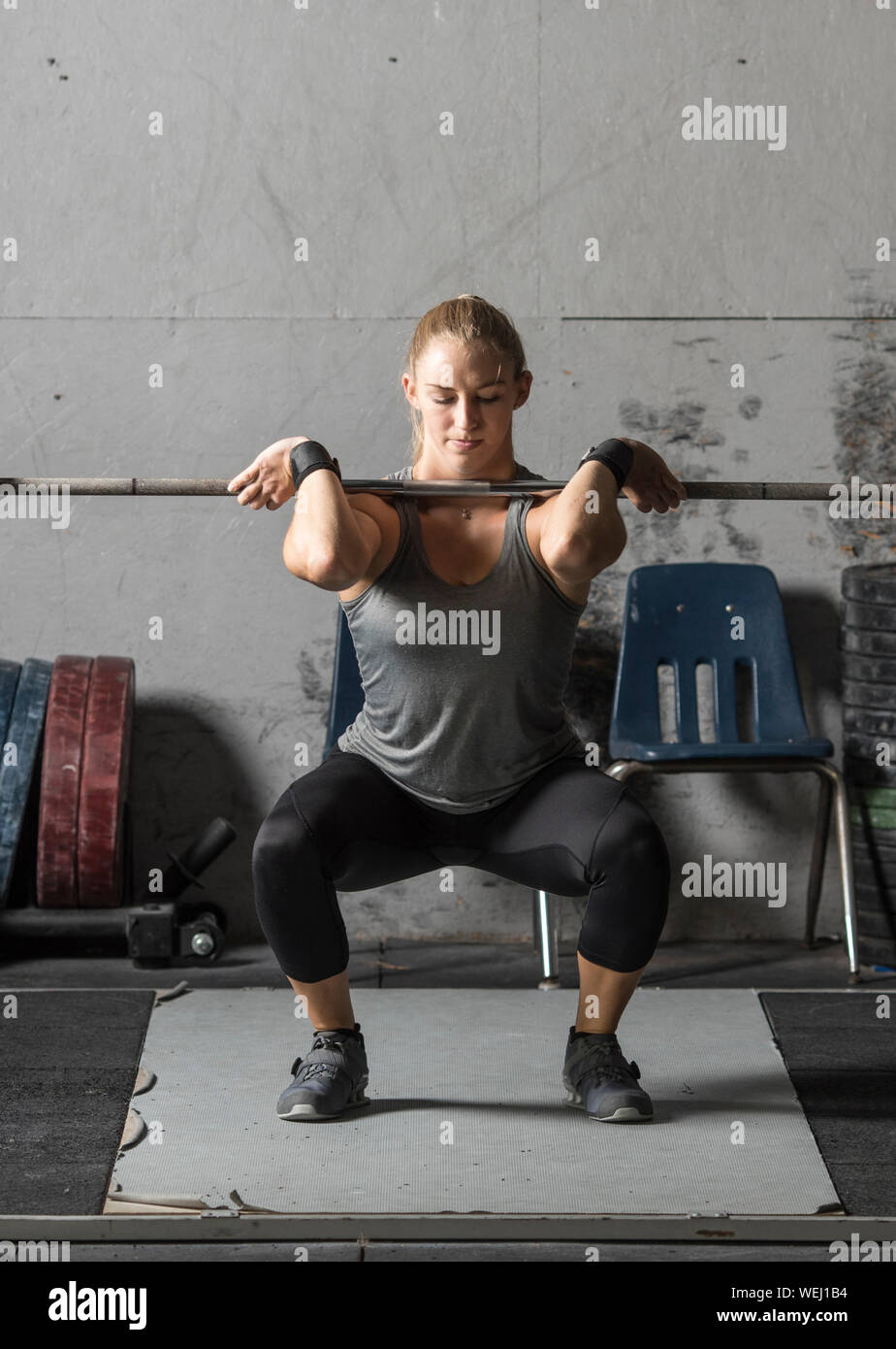 Young female powerlifter doing squats in grungy gym, closeup shot Stock Photo Alamy