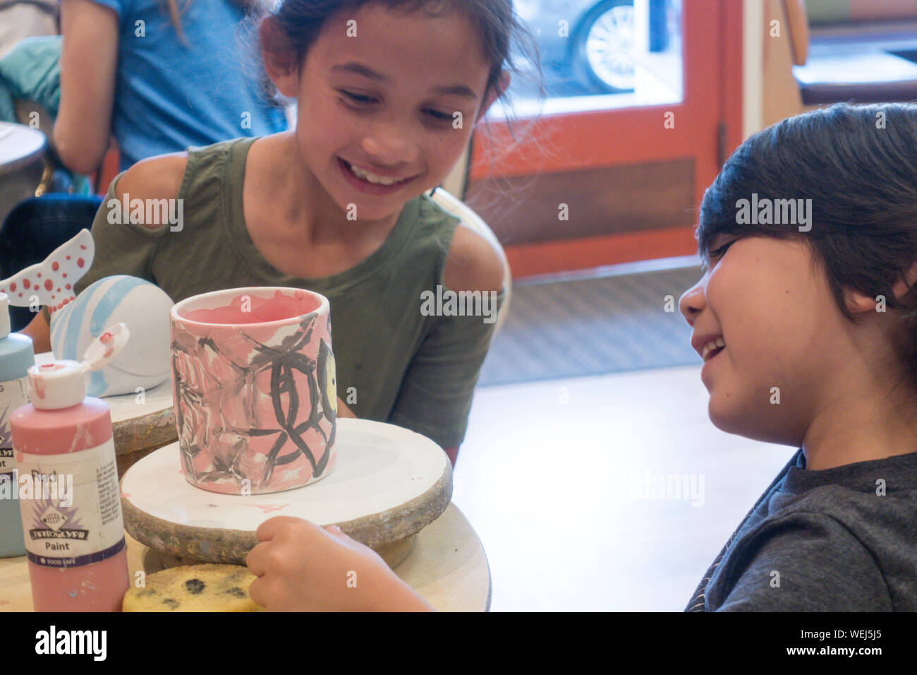 Young brother and sister in pottery class with painted mug, San Jose, California Stock Photo