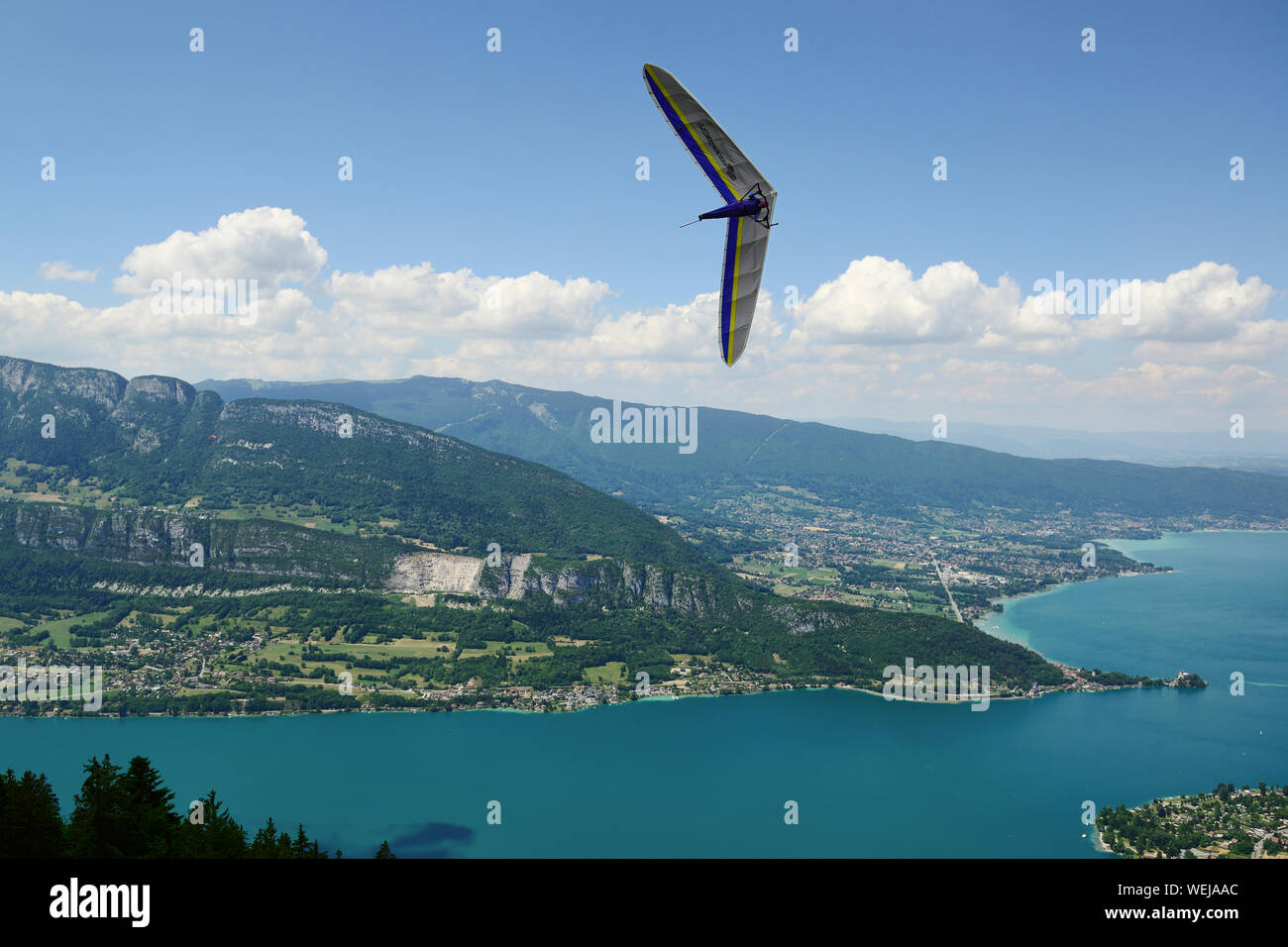 2014-06-25 Annecy; France. Hang glider pilot do extreme aerobatic maneuvers over lake Annecy. Popular place for airborne sports. Stock Photo
