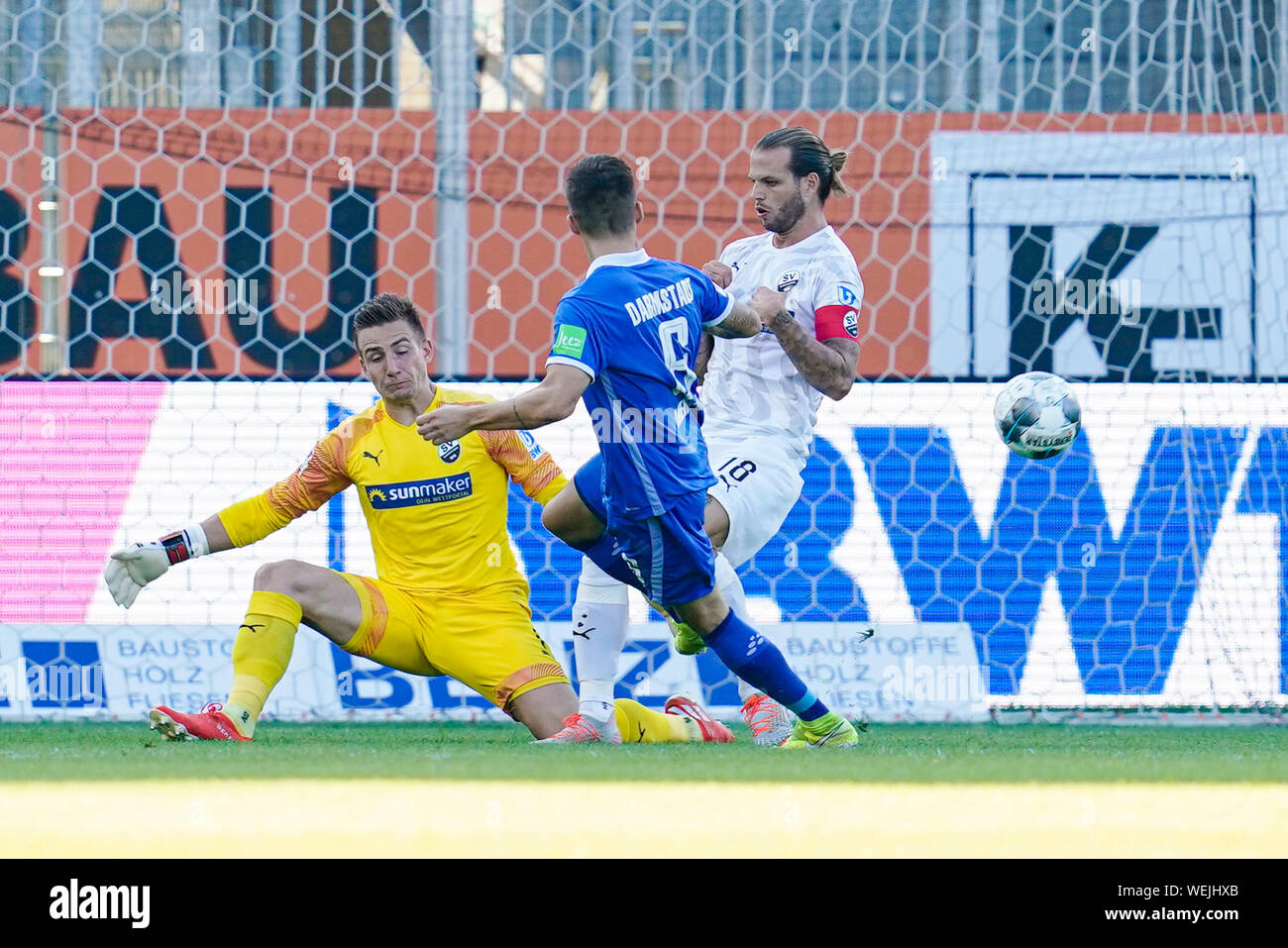 Sandhausen, Germany. 30th Aug, 2019. Soccer: 2nd Bundesliga, SV Sandhausen - SV Darmstadt 98, 5th matchday, in Hardtwaldstadion. Darmstadt's Marvin Mehlem (M) fails because of Sandhausen's goalkeeper Martin Fraisl (l) and Sandhausen's Dennis Diekmeier. Credit: Uwe Anspach/dpa - IMPORTANT NOTE: In accordance with the requirements of the DFL Deutsche Fußball Liga or the DFB Deutscher Fußball-Bund, it is prohibited to use or have used photographs taken in the stadium and/or the match in the form of sequence images and/or video-like photo sequences./dpa/Alamy Live News Stock Photo