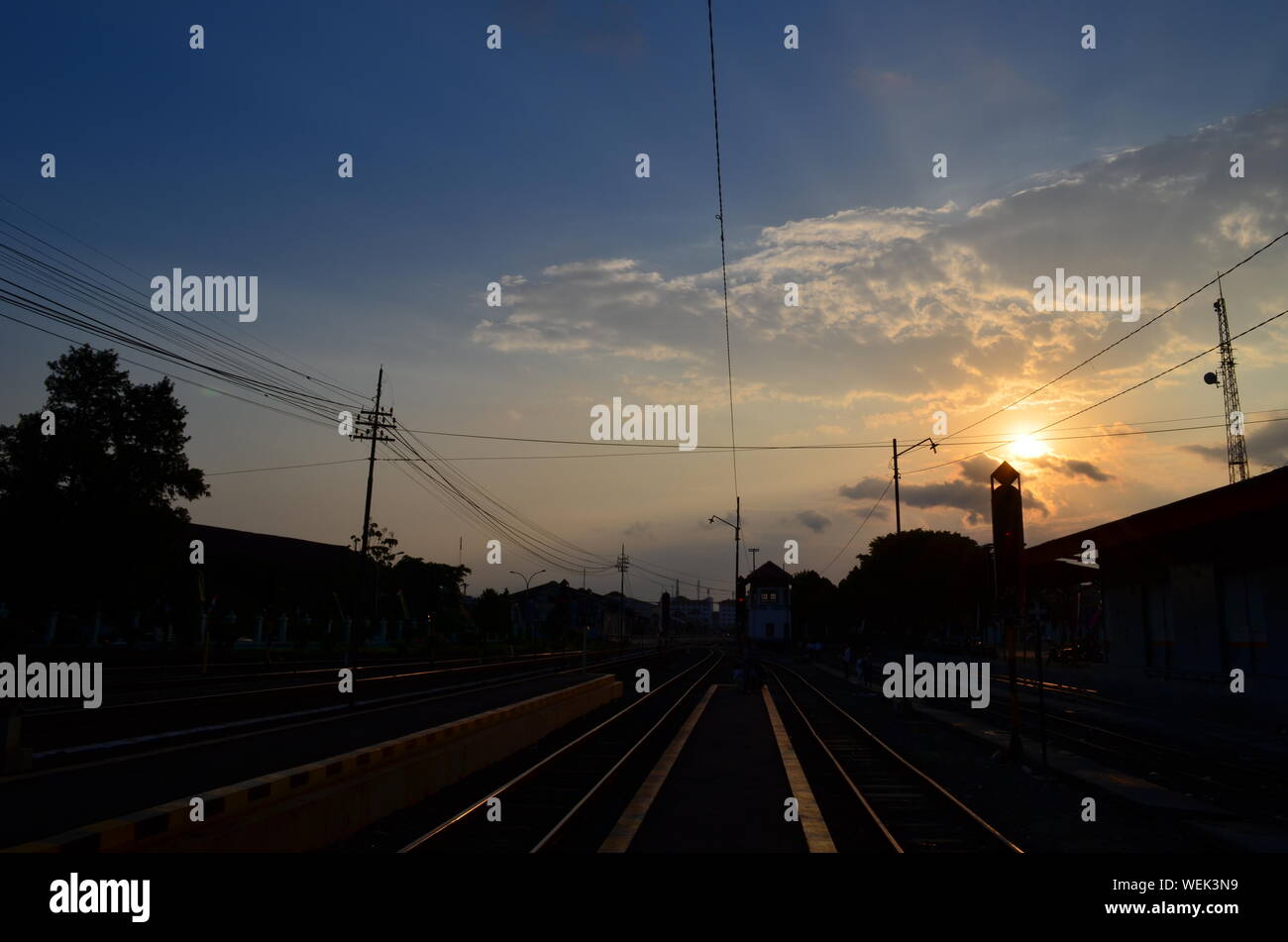 Railroad Tracks With Electricity Pylons At Sunset Stock Photo Alamy