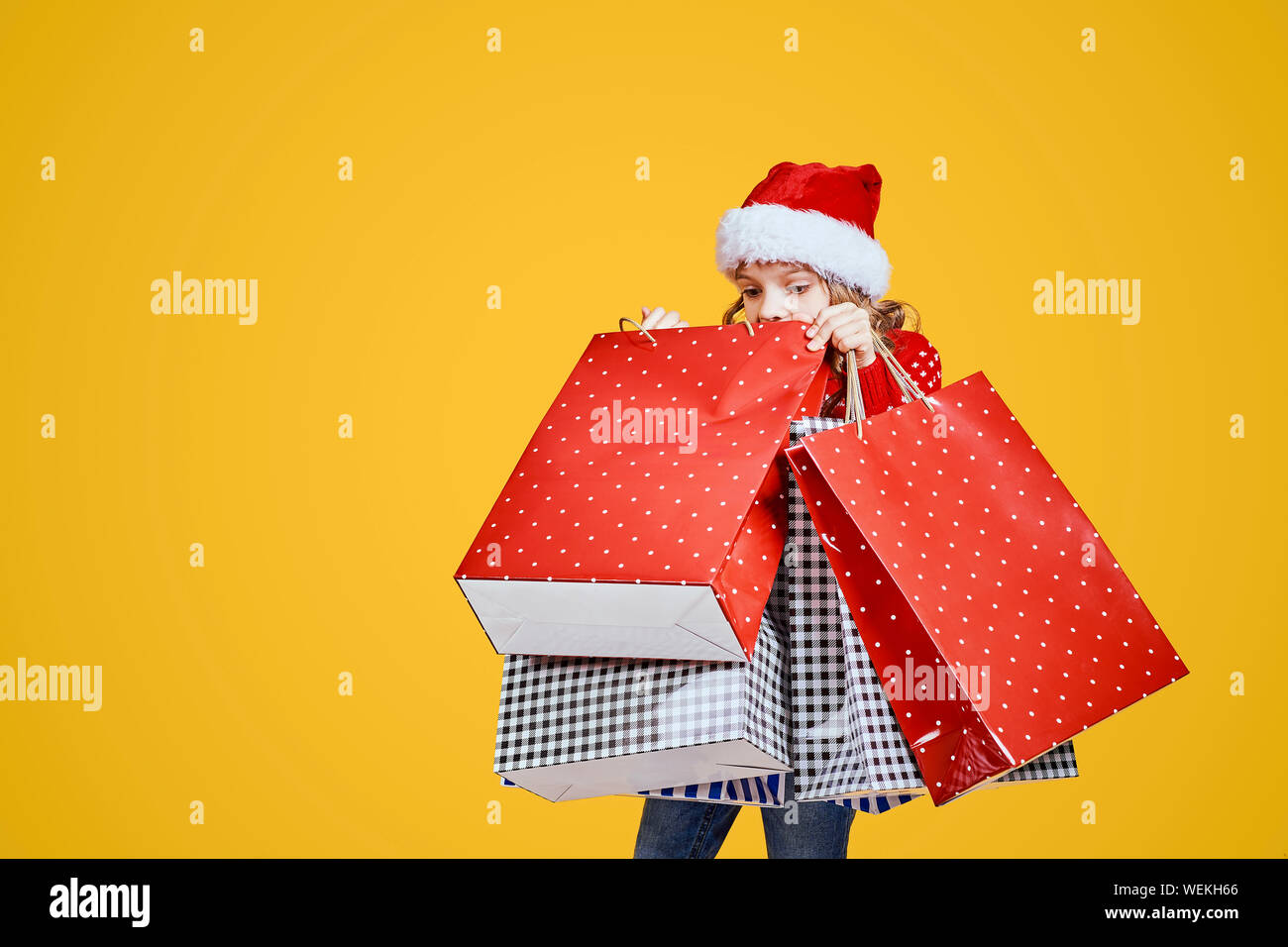 Little girl with hat carrying bags hires stock photography and images
