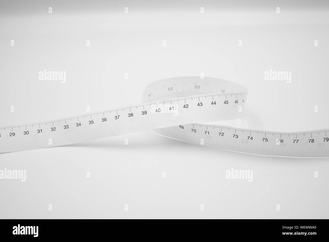 White measuring tape ruler metric measurement or diet concept isolated on white background. Stock Photo
