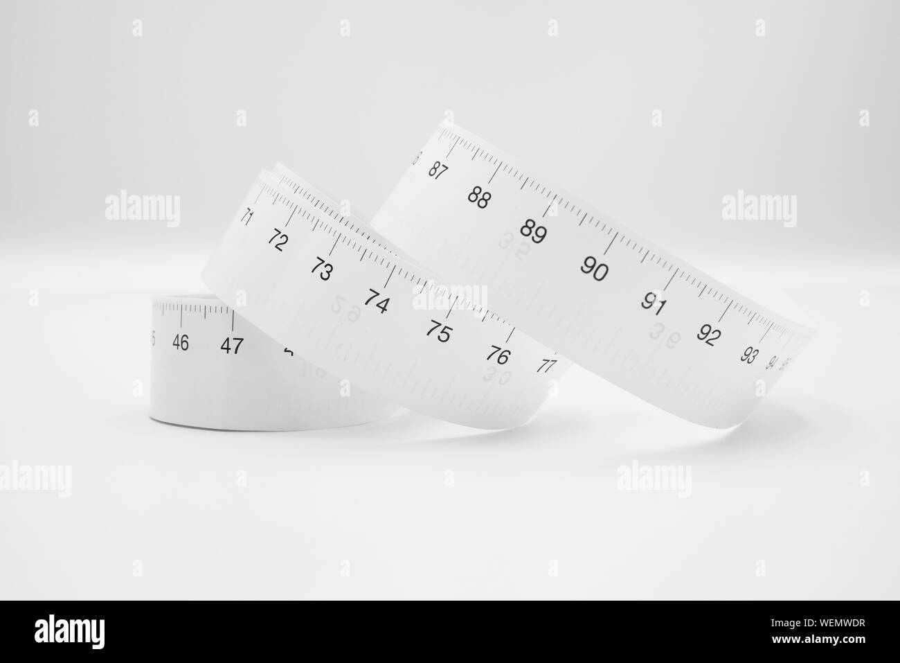 White measuring tape ruler metric measurement or diet concept isolated on white background. Stock Photo