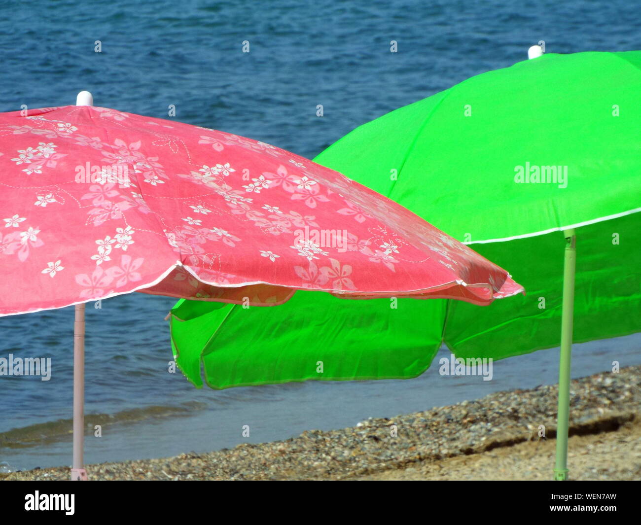 Pink And Green Parasols At Sea Shore Stock Photo