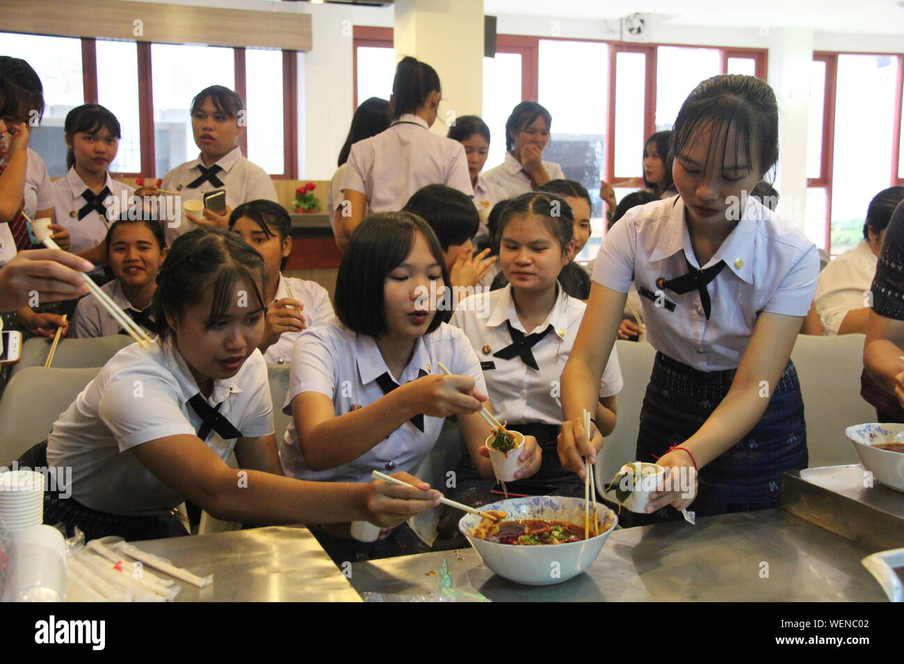 Khon Kaen, Thailand. 30th Aug, 2019. Thai students taste famous Sichuan dish 'boiled meat slices' during the third Chinese Kitchen Food and Cultural Festival held by the Confucius Institute at Khon Kaen University in Khon Kaen, Thailand, on Aug. 30, 2019. Some 600 Thai students and local people in the northeastern Thai province of Khon Kaen tasted spicy Sichuan food of China and also got a chance to learn how to cook the Sichuan dishes from top chefs from a Chinese university on Friday. Credit: Yang Zhou/Xinhua/Alamy Live News Stock Photo
