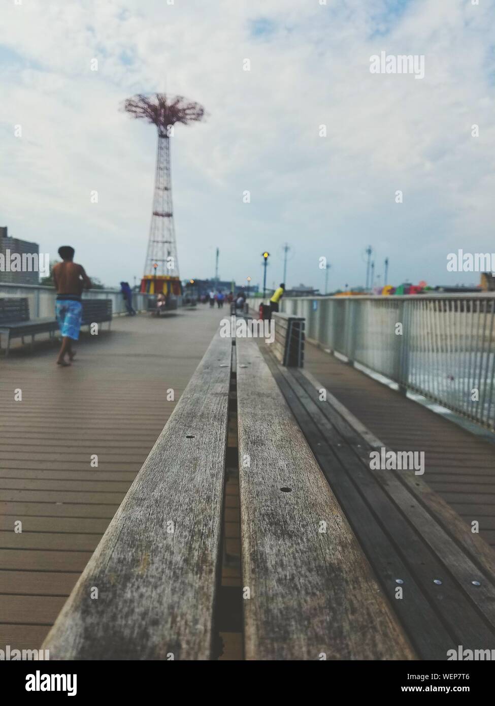 Wooden Bench Against Parachute Jump At Coney Island Stock Photo