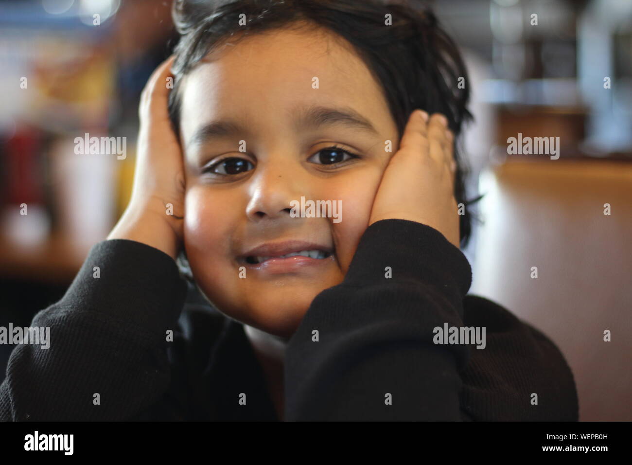 Close-up Portrait Of Girl With Hands Covering Ears Stock Photo