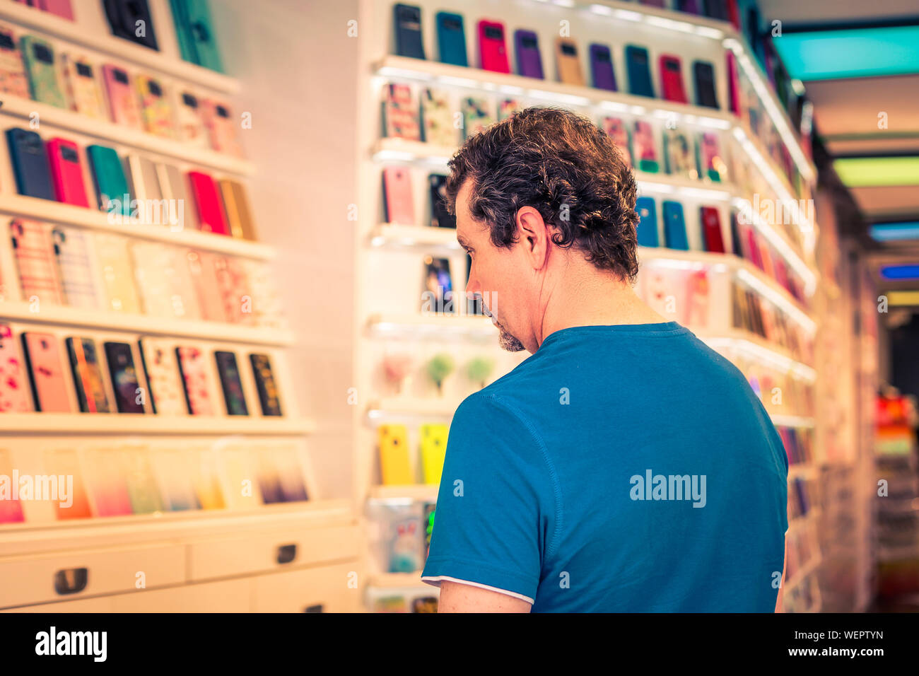customer looking at a variety of multicolored smart phone cases Stock Photo