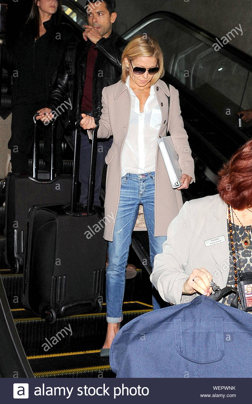 Los Angeles Ca Talk Show Host Kelly Ripa And Her Husband Mark Consuelos Touch Down At Lax This Evening Kelly Looked Chic In A White Blouse Pale Pink Coat And Cuffed