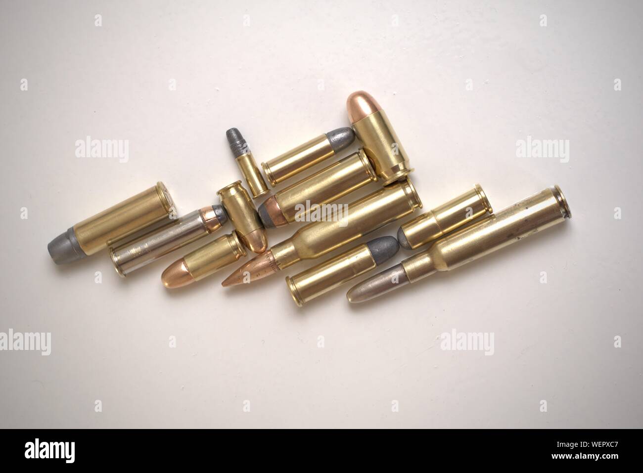 Collage of bullets of different calibers on a white background. There are several types of bullets: full metal jacket, soft point, round nose, flat no Stock Photo