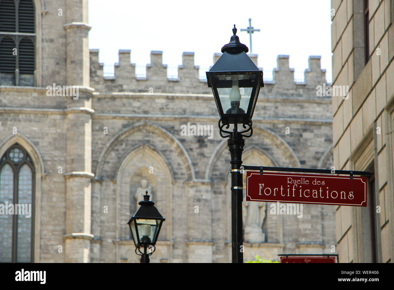 Low Angle View Of Ruelle Des Fortifications Sign On Lamp Post Against Historic Building Stock Photo