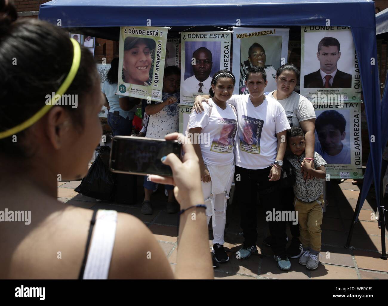 Relatives Of Missing Persons Pose For A Photo In Front Of The Portraits Of Others Missing During A Photographic Exhibition Of Victims Of This Scourge In Cali Colombia During The Commemoration Of